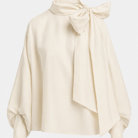 An off-white satin blouse with a high neck, large bow at the collar, and balloon sleeves, shown on a light gray background.