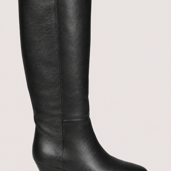 A single black leather knee-high boot with a low block heel and pointed toe, shown in profile against a light beige background.
