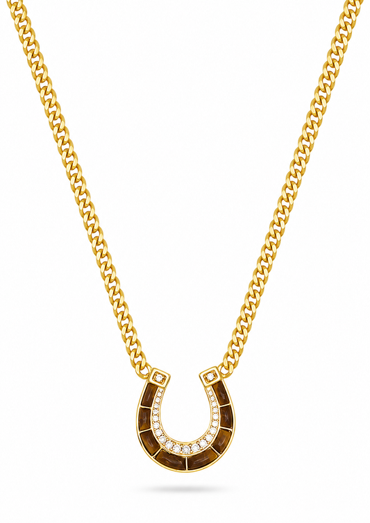 A gold chain necklace with a horseshoe-shaped pendant, displayed on a clean white background.