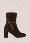 A dark brown suede ankle boot with a block heel and a matching dark brown leather strap detail around the ankle, shown against a solid light beige background.