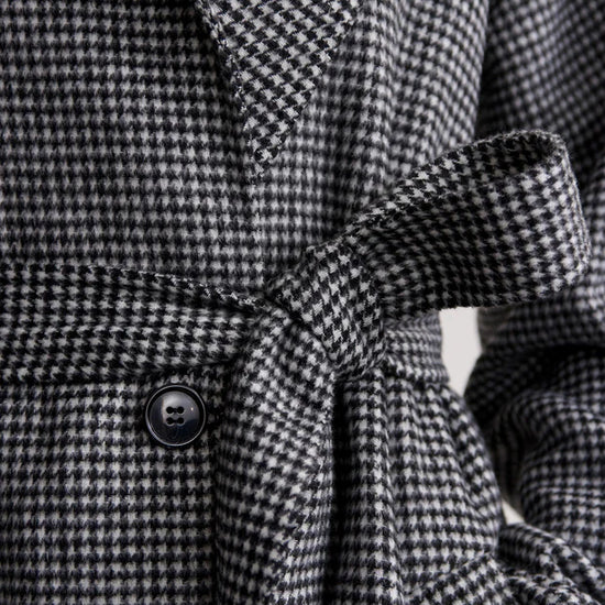 black houndstooth coat with tie belt close up