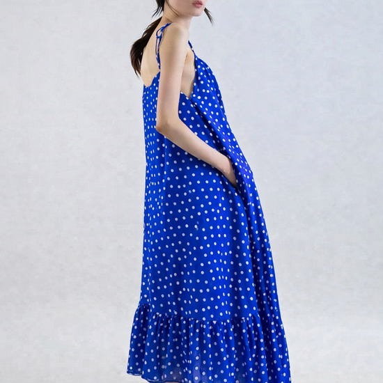 Woman wearing a blue polka dot dress on a white background