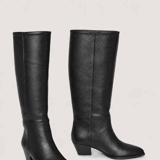 A pair of black leather knee-high boots with low block heels and pointed toes, displayed against a solid light gray background.