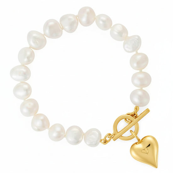Pearl bracelet with a gold clasp and heart charm on a white background