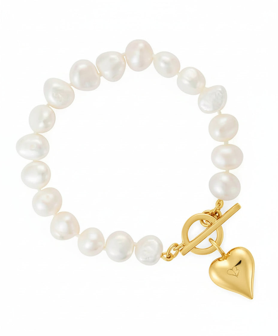Pearl bracelet with a gold clasp and heart charm on a white background