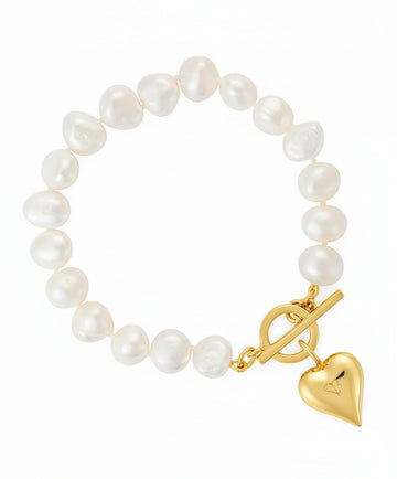 Pearl bracelet with a gold clasp and heart charm on a white background