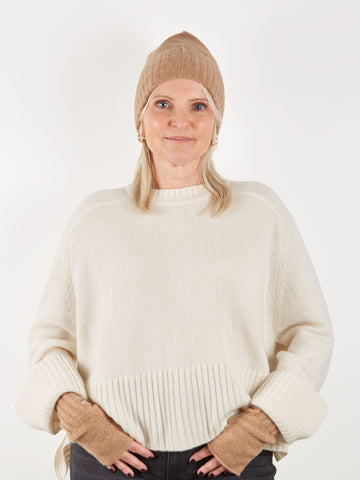 Camel coloured beanie hat and wrist warmer set on model with cream knit