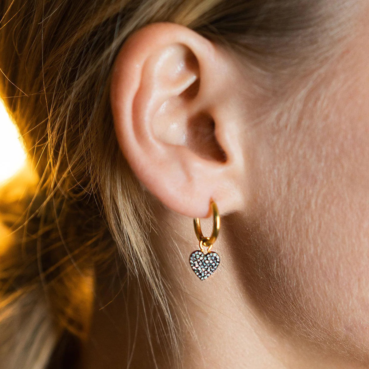 Gold hoop earrings with pave diamond heart pendant