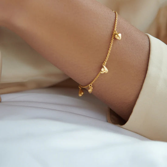 gold chain bracelet with gold heart charms and a lobster clasp from rachel jackson model shot