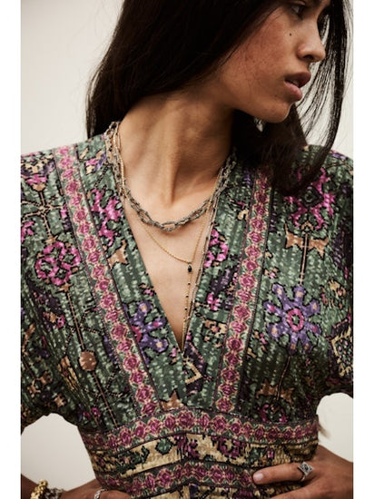 Woman wearing a patterned top with a neutral background
