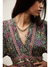 Woman wearing a patterned top with a neutral background