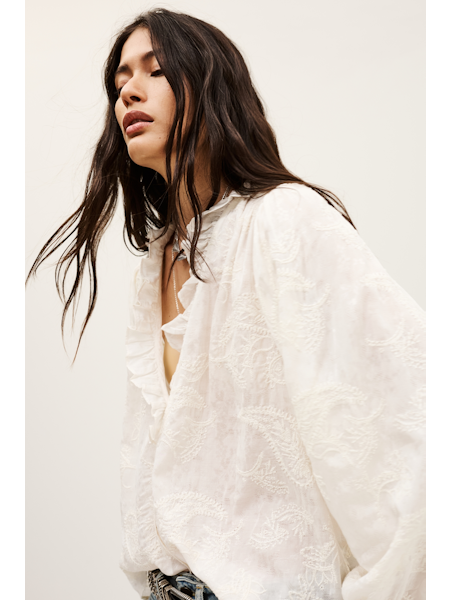Woman wearing a white textured top against a plain background from ba&sh
