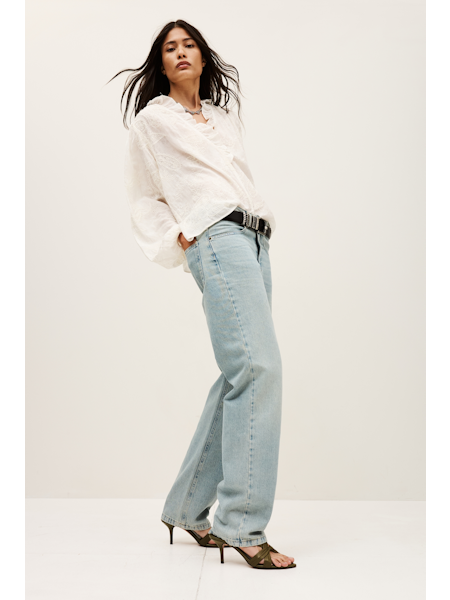 Woman wearing a white blouse and light blue jeans on a white background from  ba&sh