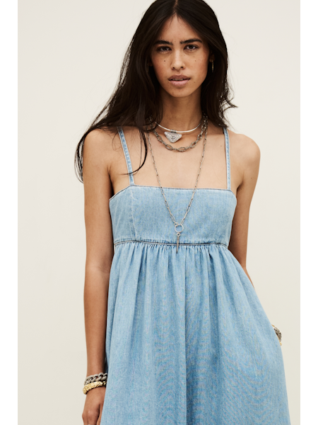 Woman wearing a light blue dress with a neutral background