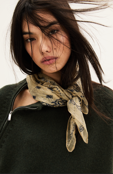 Woman wearing a patterned scarf with a neutral background