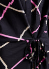 Black dress with pink and beige geometric pattern by Essentiel Antwer close up 