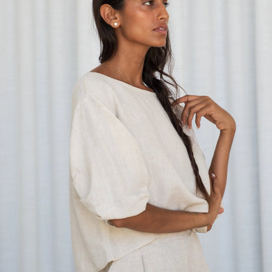Woman wearing a white outfit against a light gray curtain background from Lilly Pilly