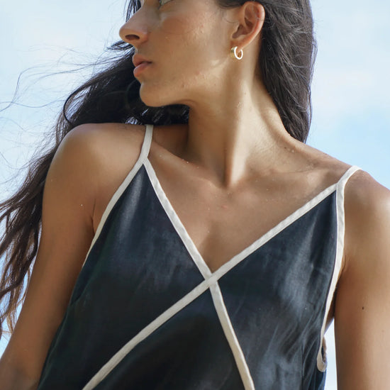 Woman wearing a black and white dress against a clear blue sky