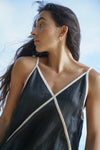 Woman wearing a black and white dress against a clear blue sky