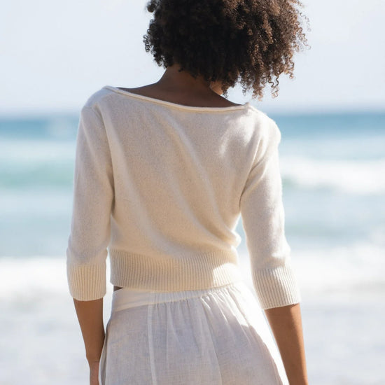 V neck rolled hem cardigan in ivory with three quarter length sleeves and shell buttons