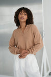 Woman wearing a camel sweater and white pants against a neutral background from Lilly Pilly