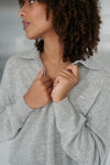 Woman wearing a gray sweater with a blurred background