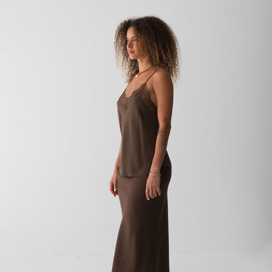 Woman wearing brown cami and skirt set side view