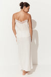 A woman shown from the back wearing a two-piece slip set consisting of a cream camisole with lace trim and a matching long skirt, set against a plain white studio background with a soft shadow.