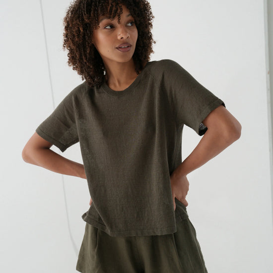 Woman wearing an olive green outfit against a white background