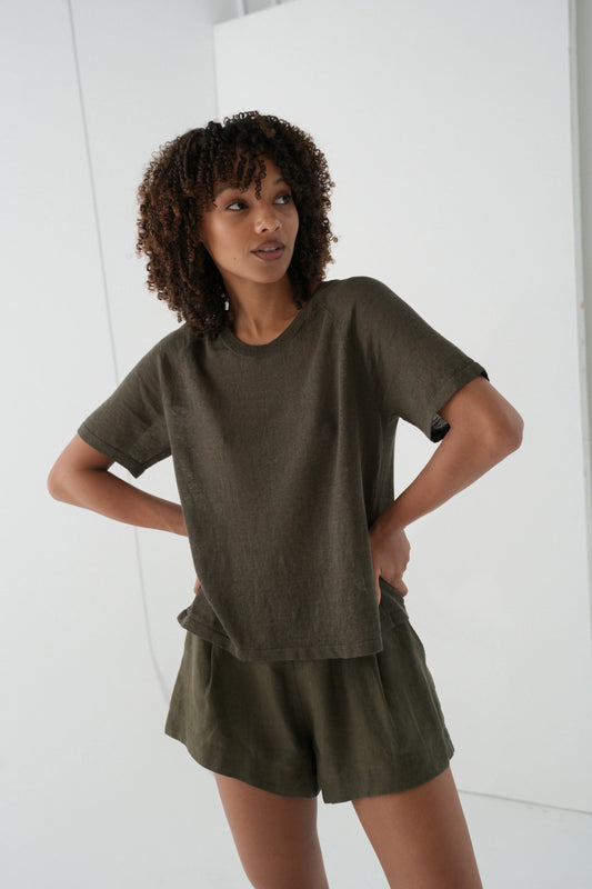 Woman wearing an olive green outfit against a white background