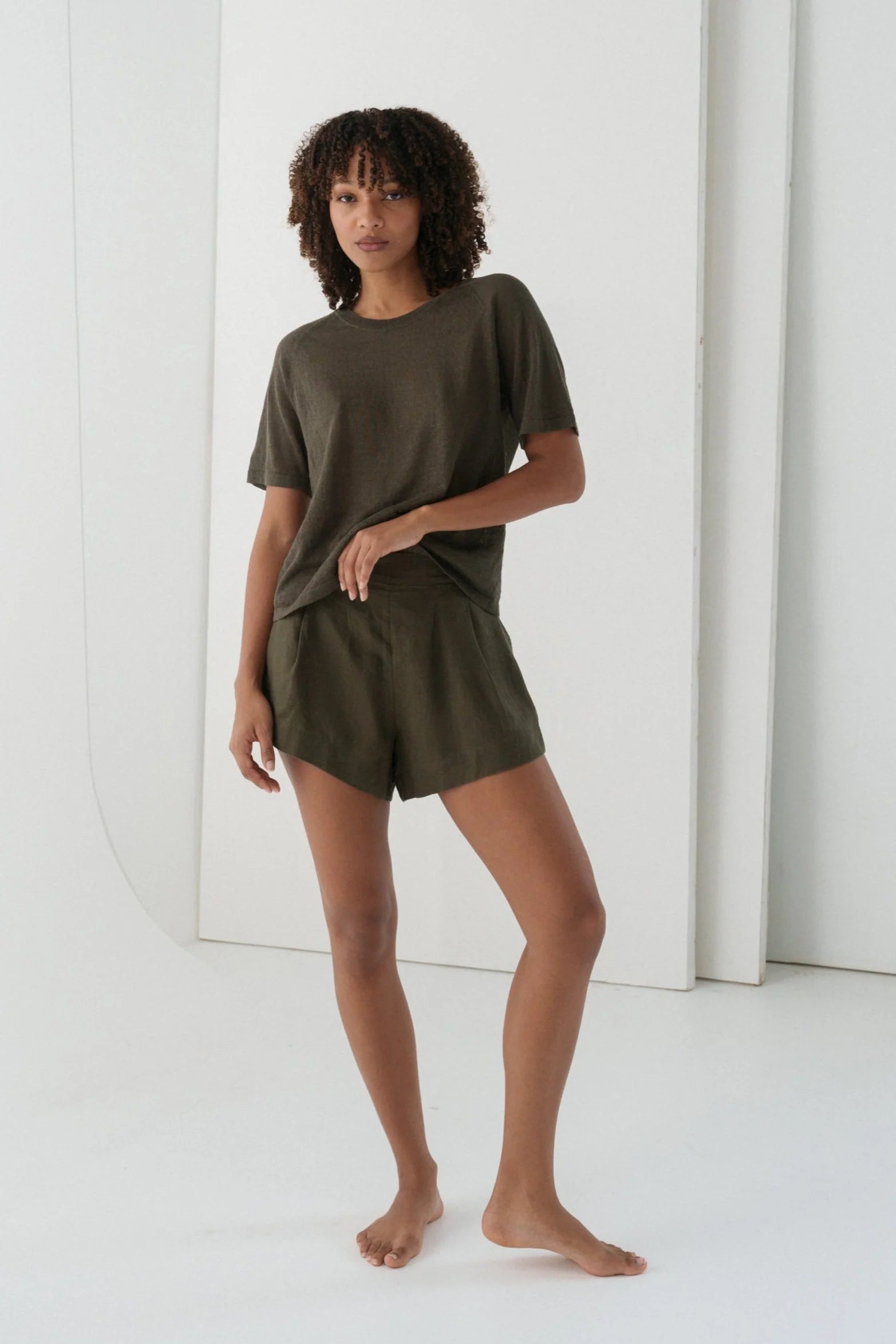 Woman wearing an olive green outfit against a white background