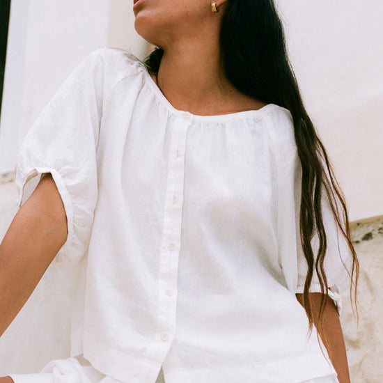 Woman wearing a white outfit against a light background