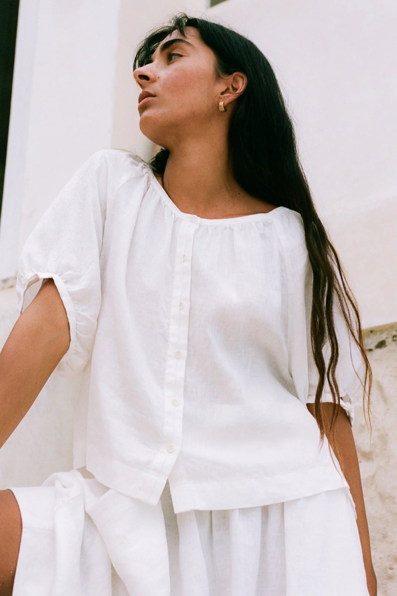 Woman wearing a white outfit against a light background