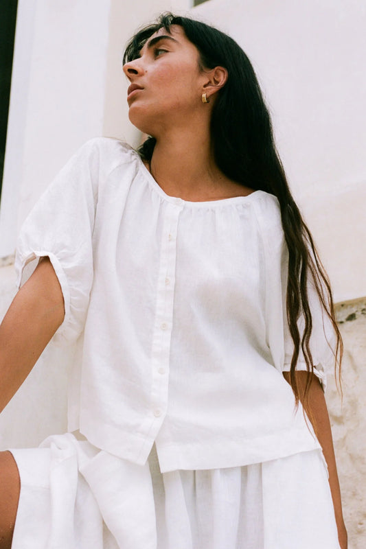 Woman wearing a white outfit against a light background