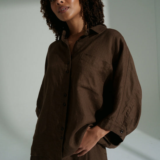 Woman wearing a brown outfit against a plain background