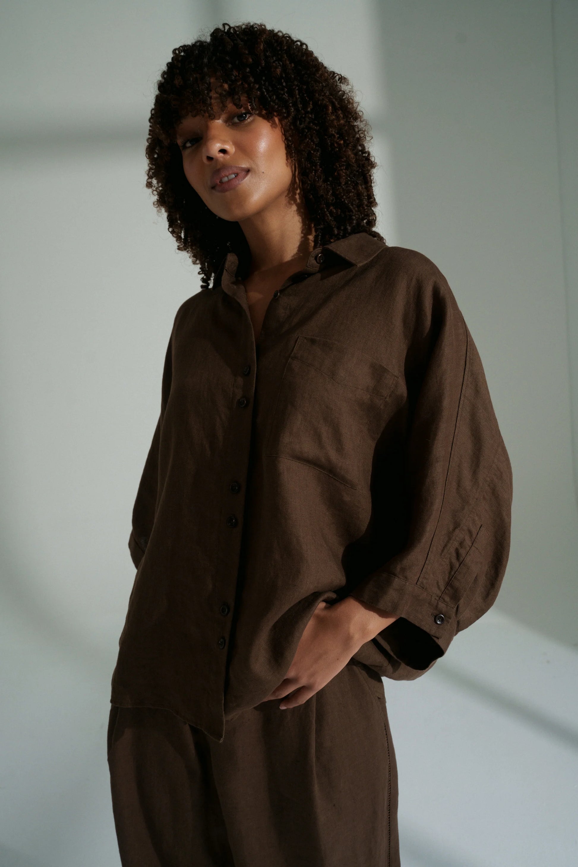 Woman wearing a brown outfit against a plain background