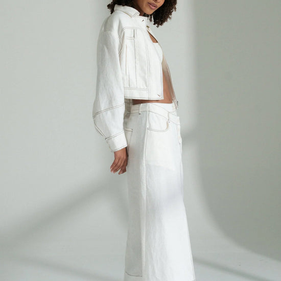 Woman wearing a white outfit against a plain background