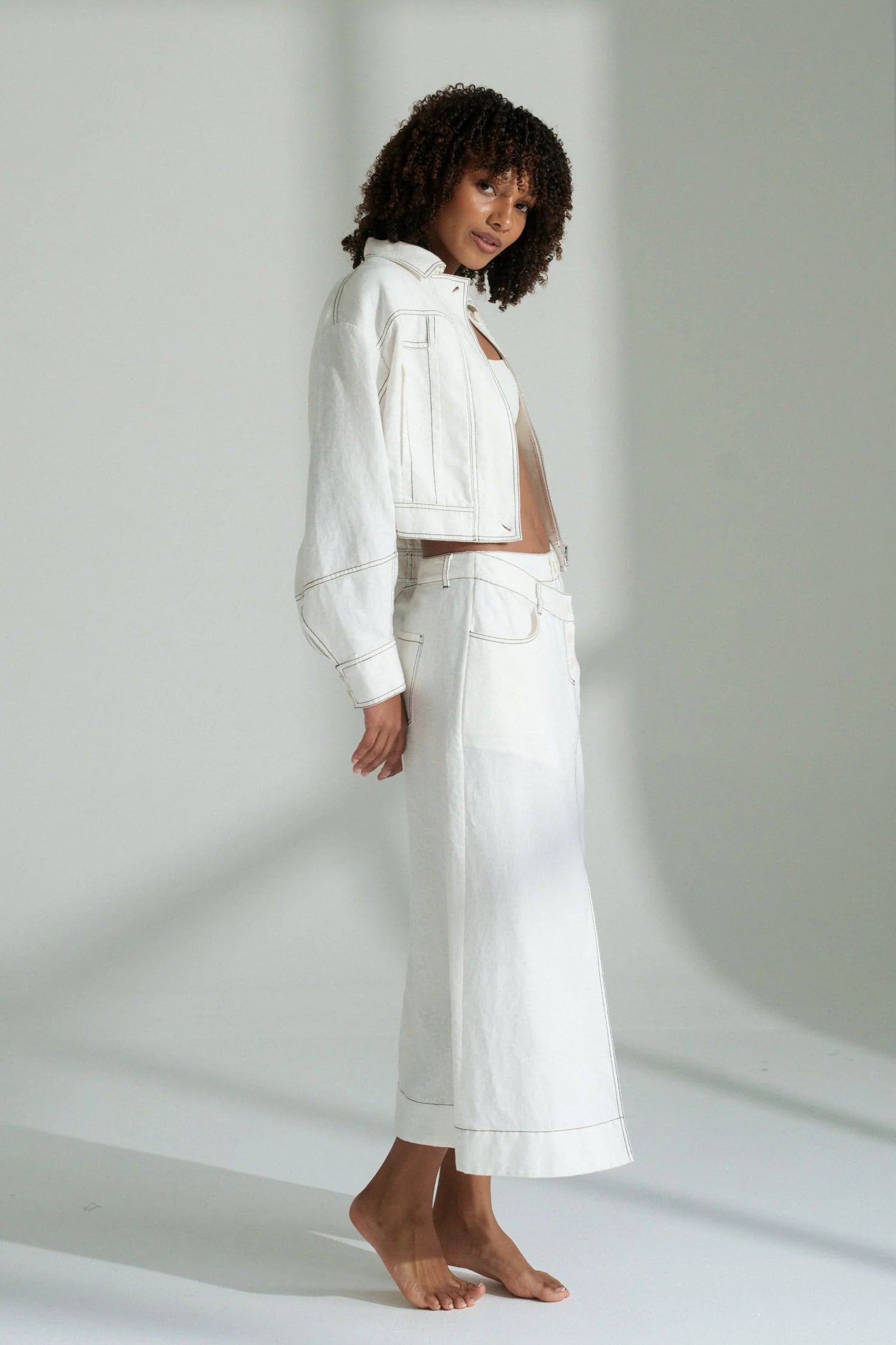 Woman wearing a white outfit against a plain background
