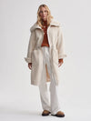 cream sherpa coat with high neck, 2 large patch pockets and drawstring waist model shot