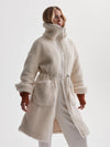 cream sherpa coat with high neck, 2 large patch pockets and drawstring waist side view 