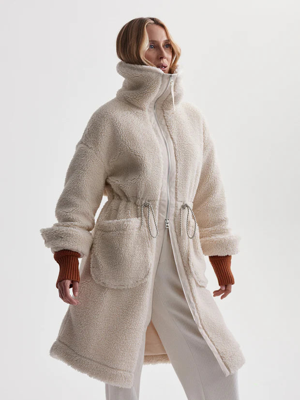 cream sherpa coat with high neck, 2 large patch pockets and drawstring waist side view 