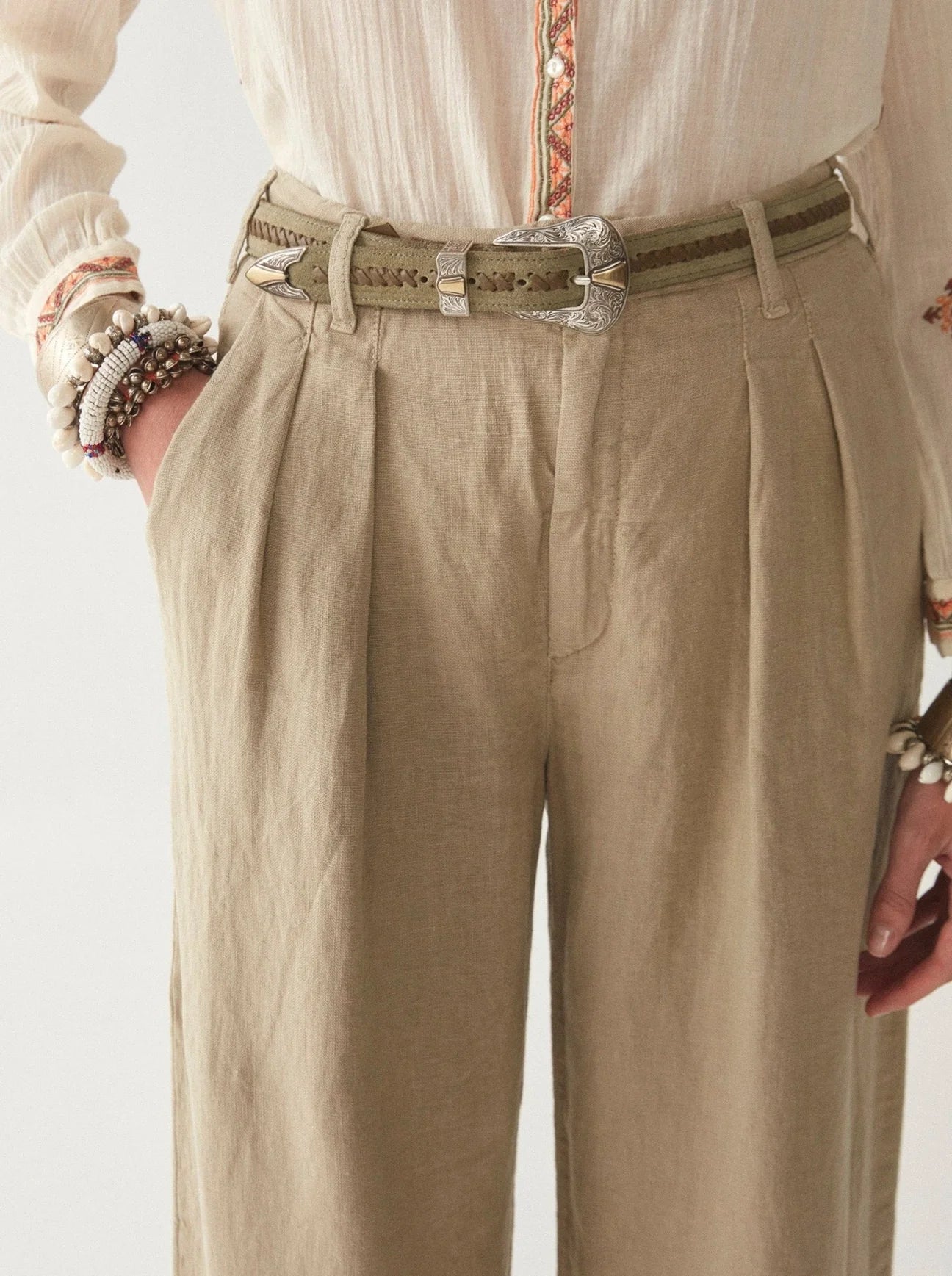 Light khaki wide leg linen trousers with pleated front zip fly and button fastening