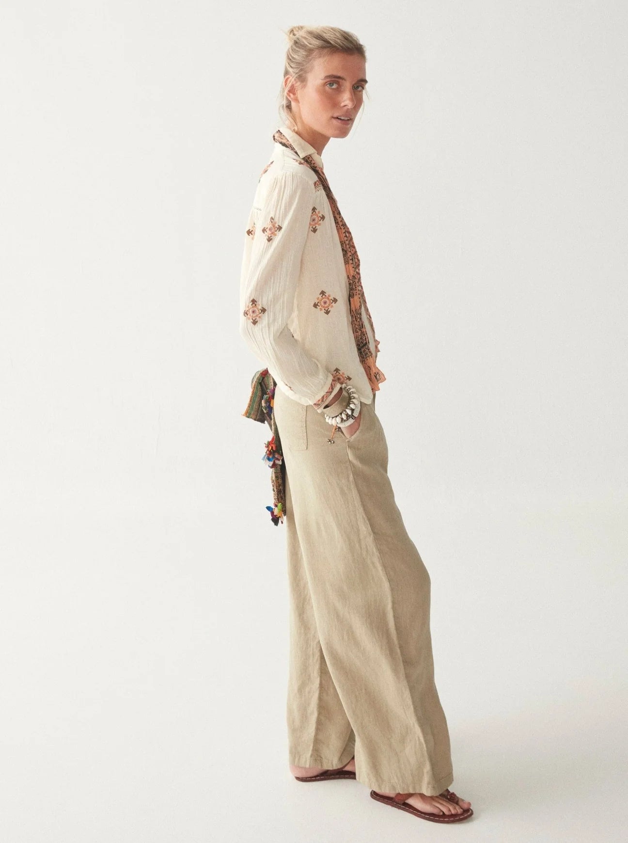 Light khaki wide leg linen trousers with pleated front zip fly and button fastening