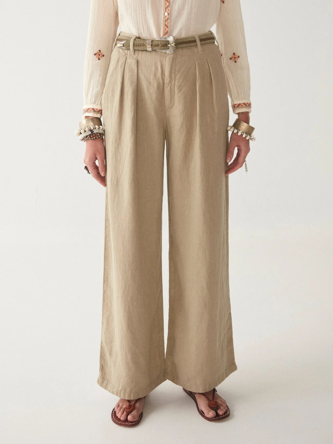 Light khaki wide leg linen trousers with pleated front zip fly and button fastening