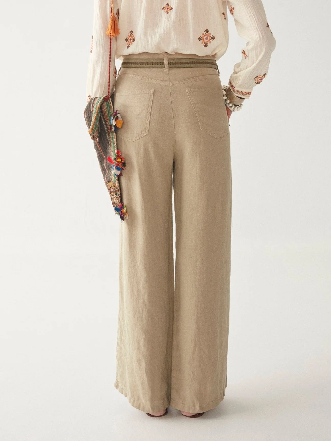 Light khaki wide leg linen trousers with pleated front zip fly and button fastening