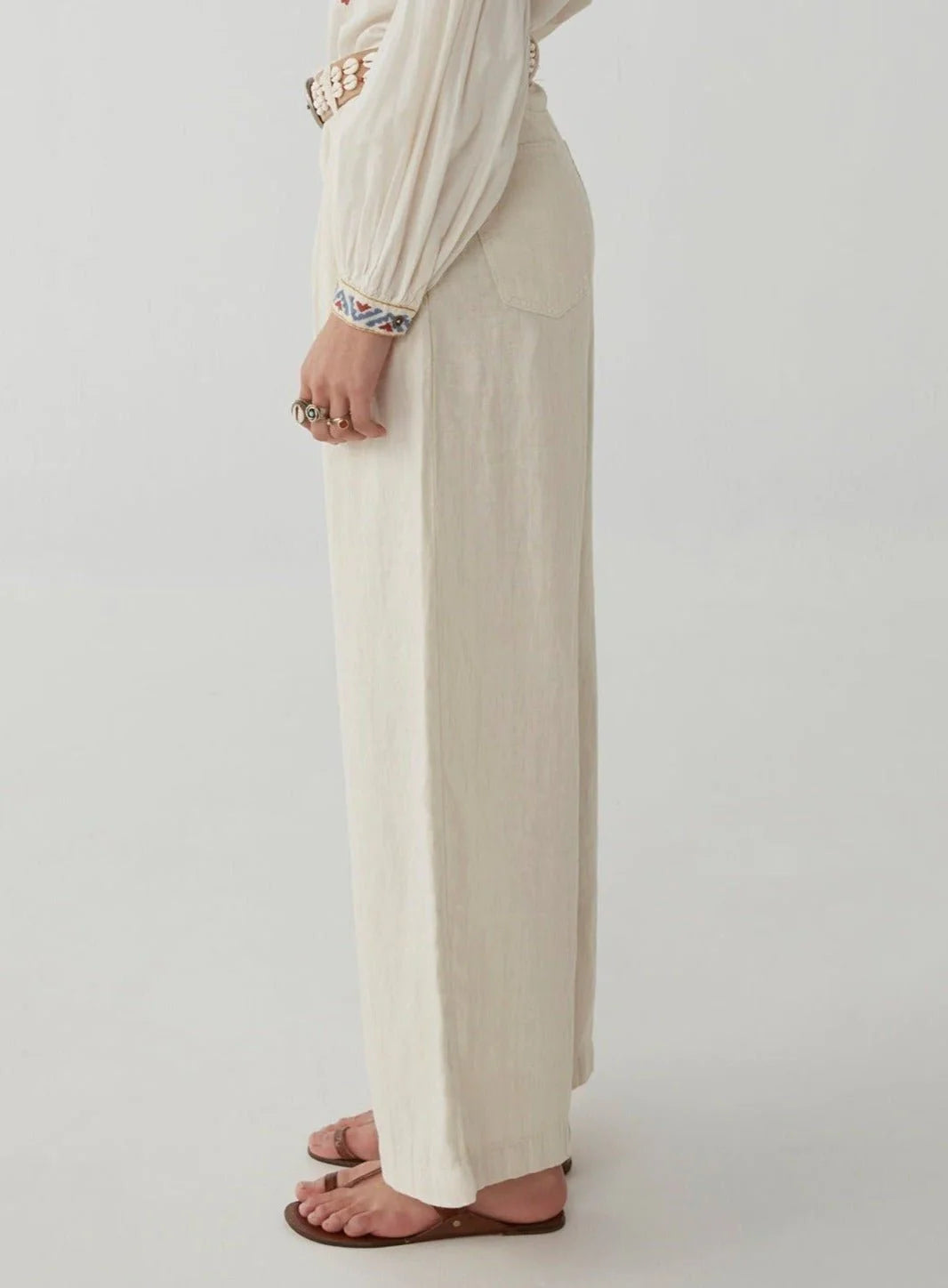 Ecru wide leg linen trousers with pleated front zip fly and button fastening