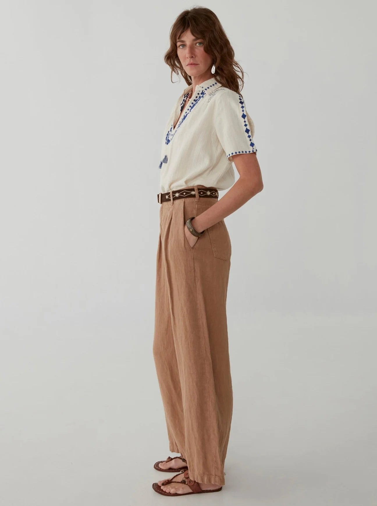 Light brown wide leg linen trousers with pleated front zip fly and button fastening