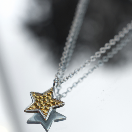 Silver chain with star pendant with small gold dots