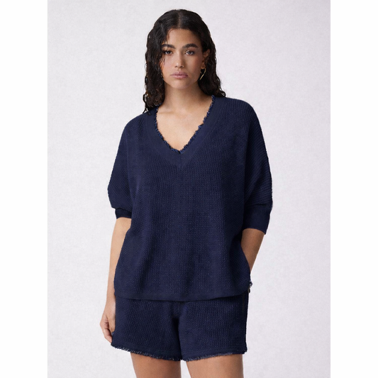 Woman wearing a navy blue outfit with a matching top and shorts on a white background