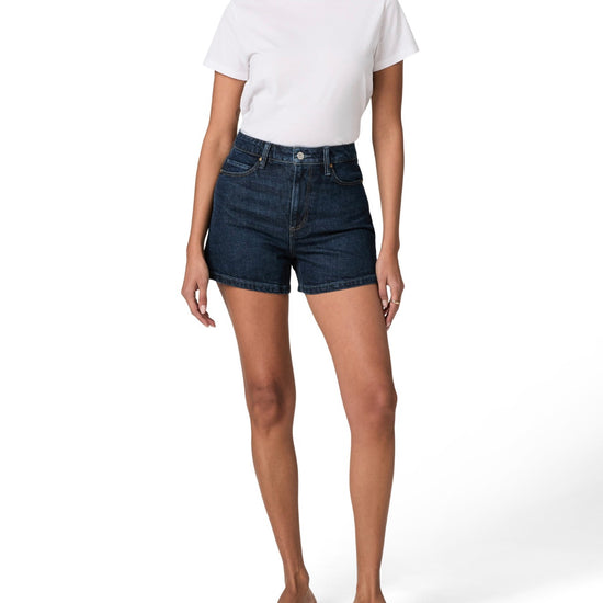 Person wearing dark denim shorts and a white t-shirt on a white background